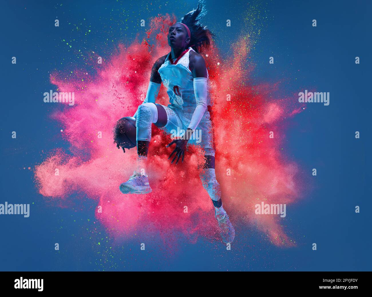 One young woman sportsman basketball player in explosion of colored