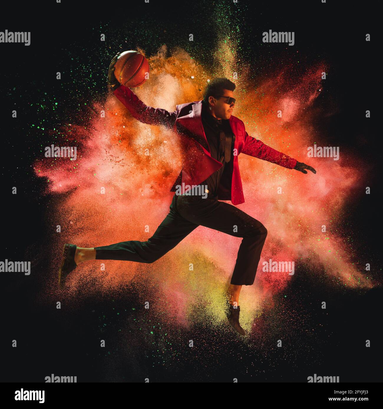 One young sportsman basketball player in explosion of colored neon