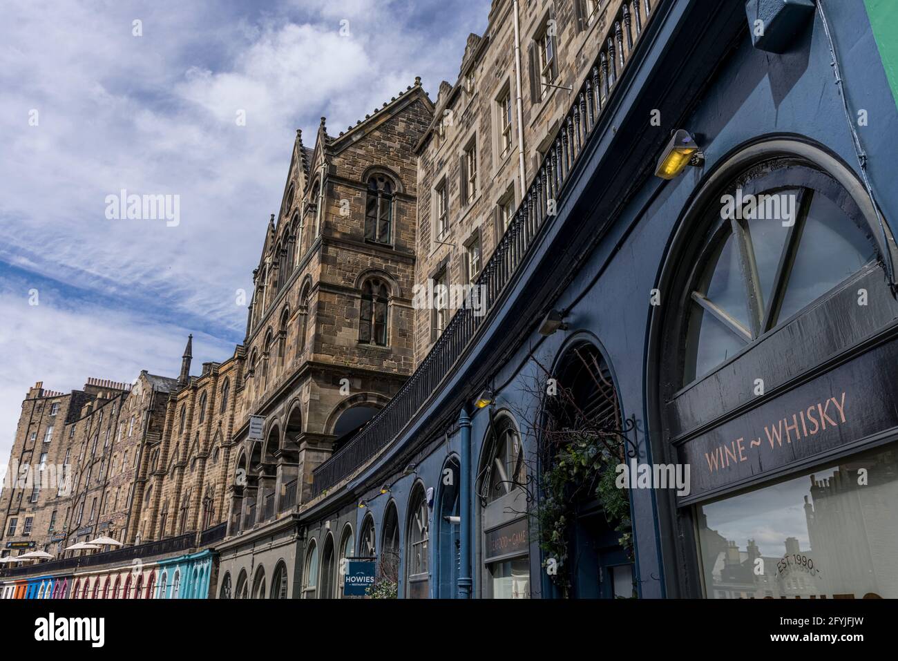 A photograph of the Harry Potter inspired Victoria Street in Edinburgh. Looking up to the second level. A window is inscribed Wine and Whisky Stock Photo
