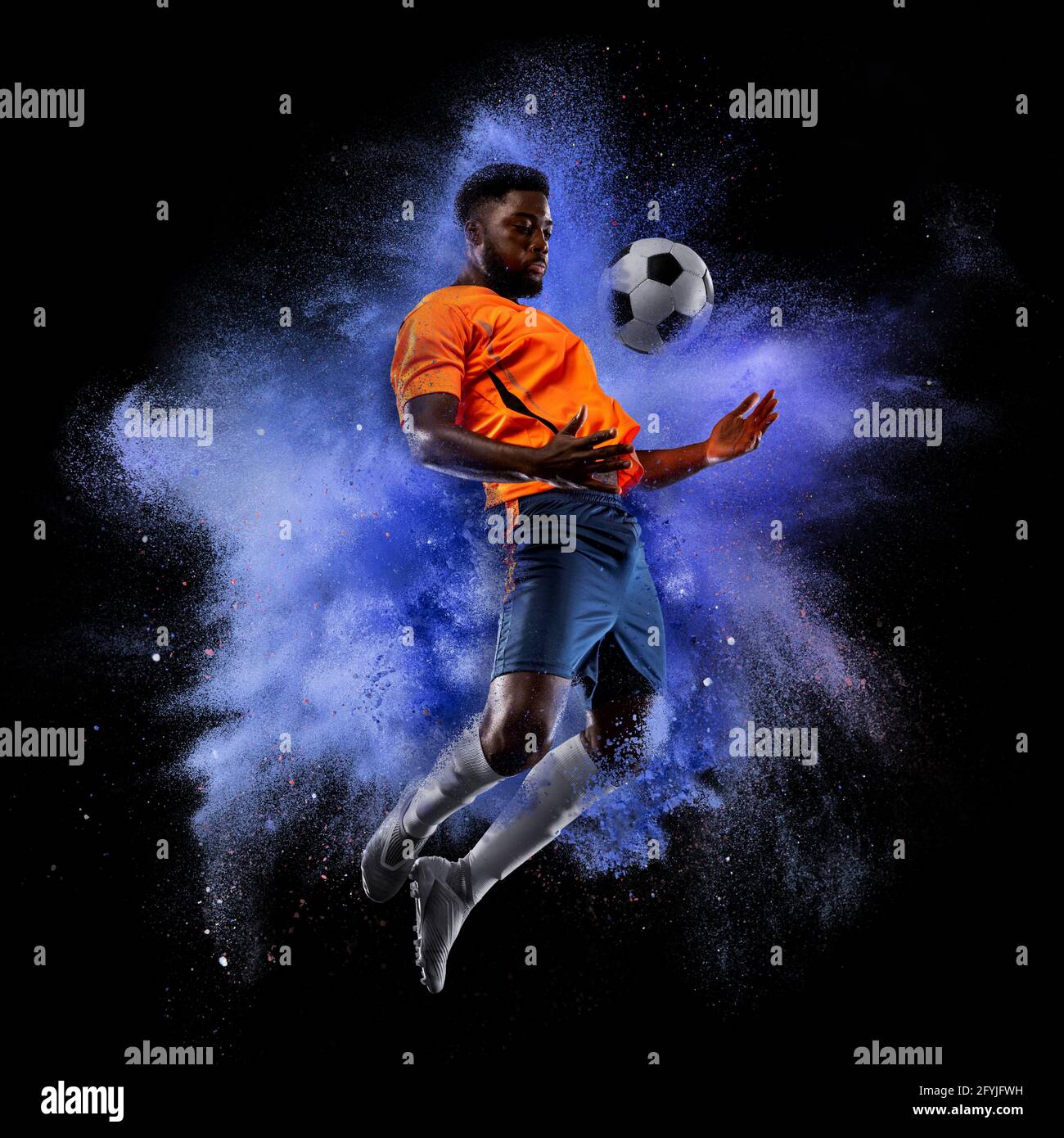 One young sportsman soccer football player in explosion of colored neon