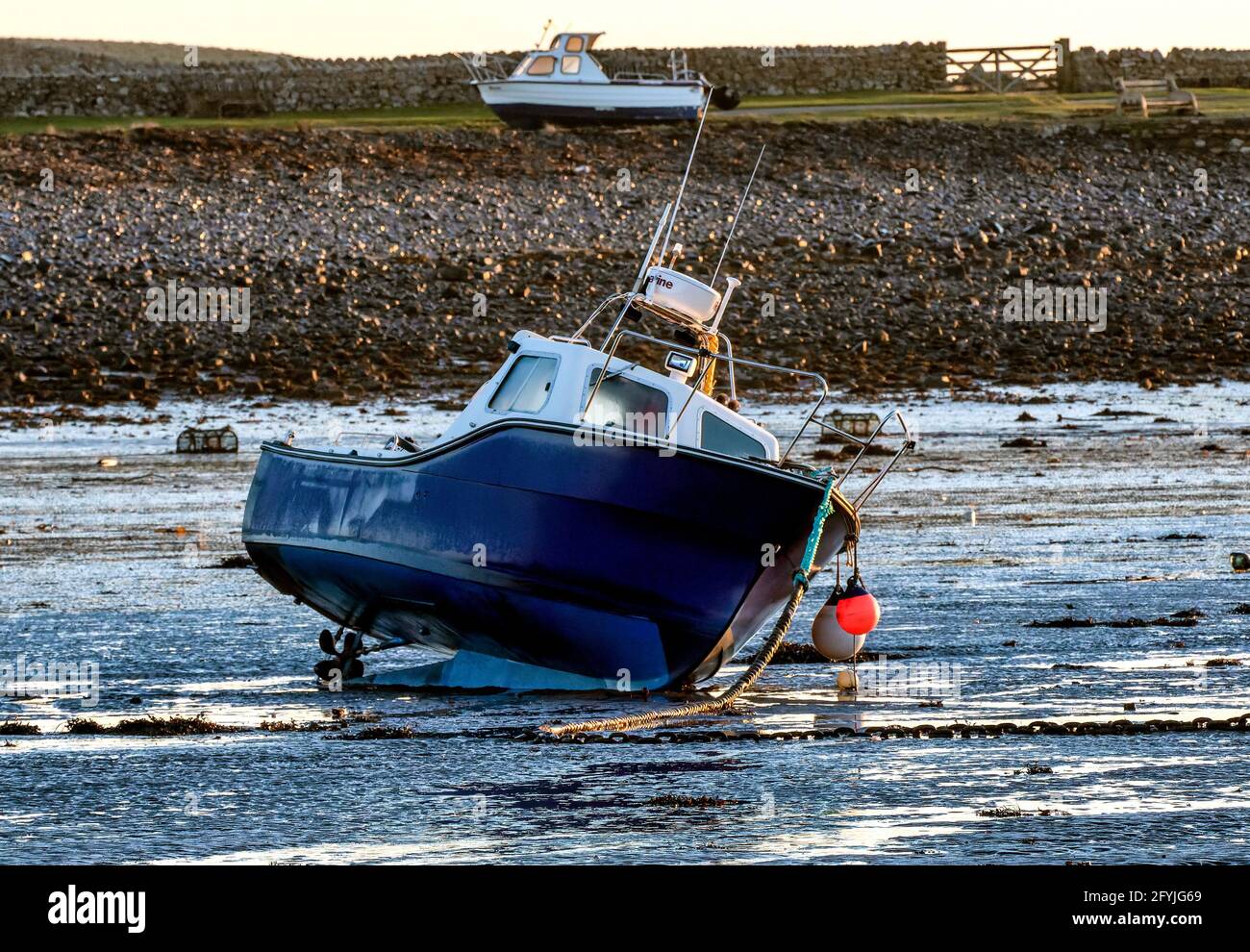 Boat listing on its side at low tide Stock Photo