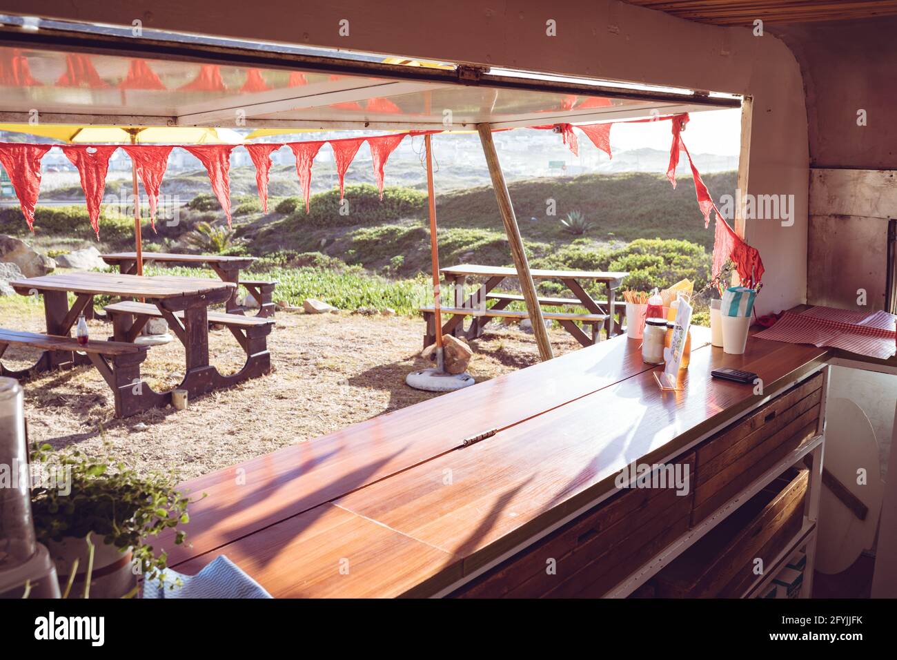 General view of food truck with red bunting and outside seating Stock Photo