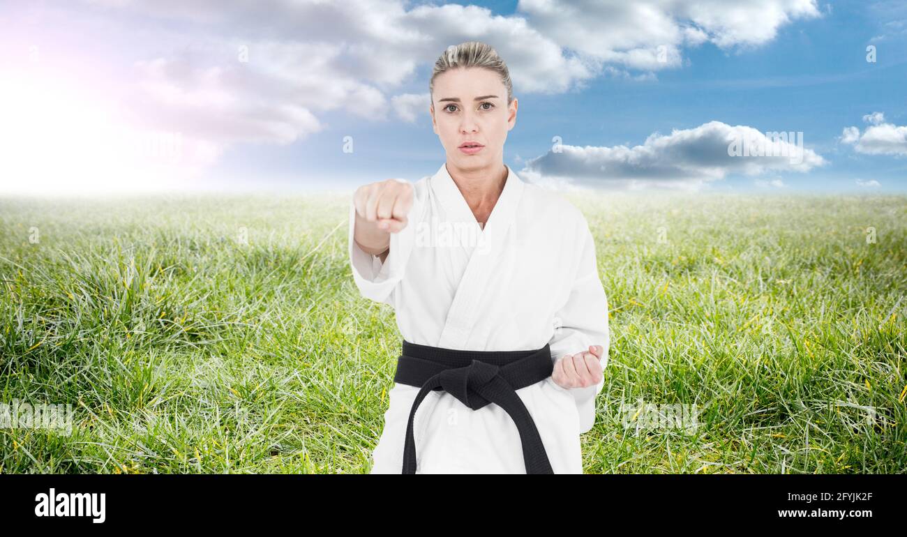 Composition of female martial karate artist with black belt practicing in countryside Stock Photo