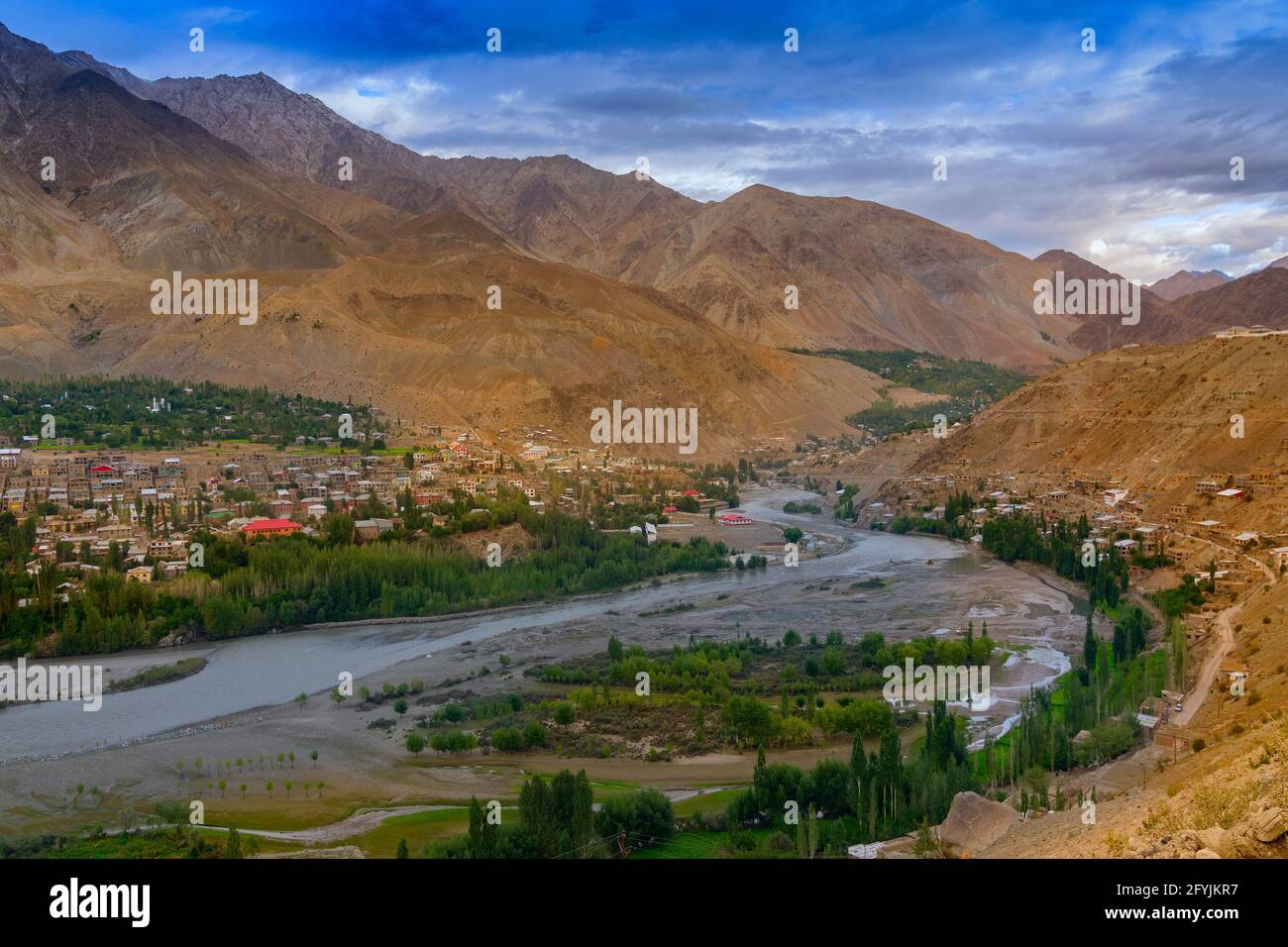 Indus river turns around Kargil City valley with Himalayan mountains and blue cloudy sky in background, Leh, Ladakh, Jammu and Kashmir, India Stock Photo