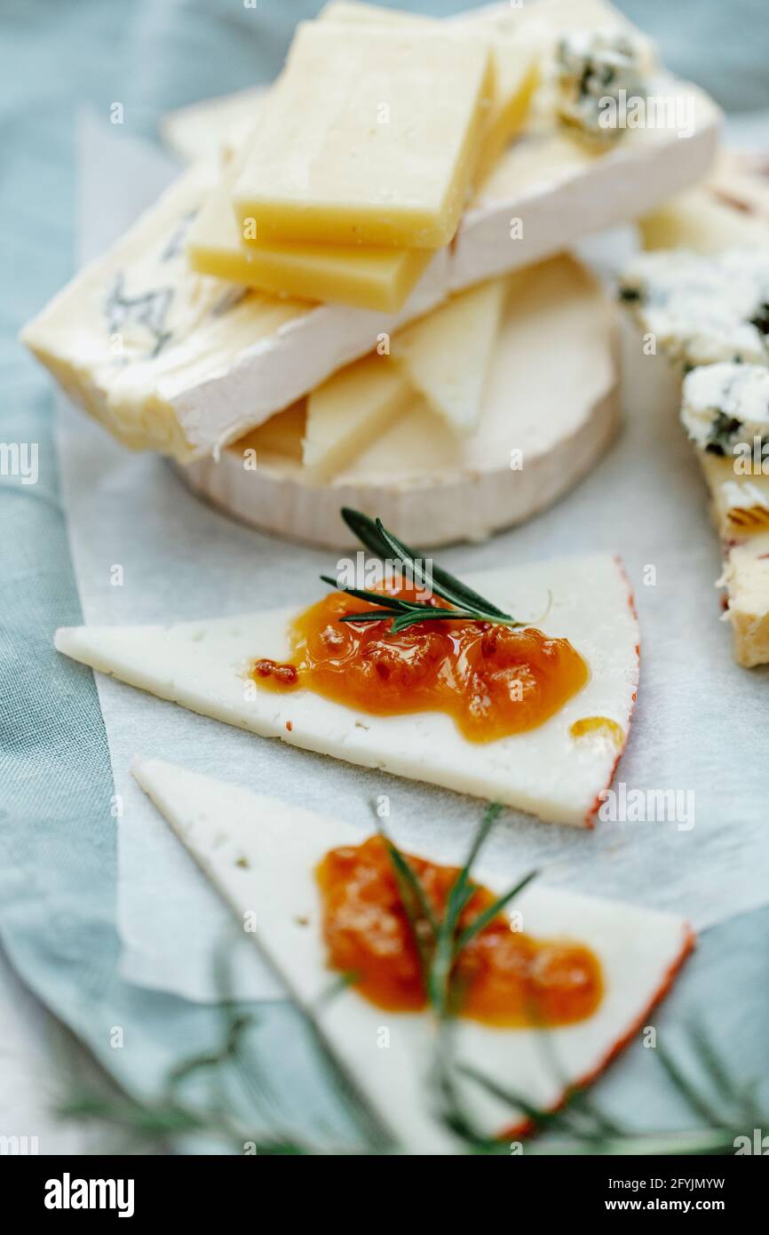 Close-up of a cheese board with a stack of blue cheese, cheddar, goats cheese and chutney Stock Photo