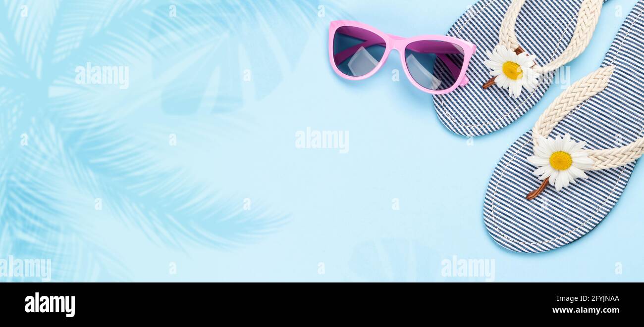 Beach flip flops with flowers and sunglasses on blue background. Summer ...