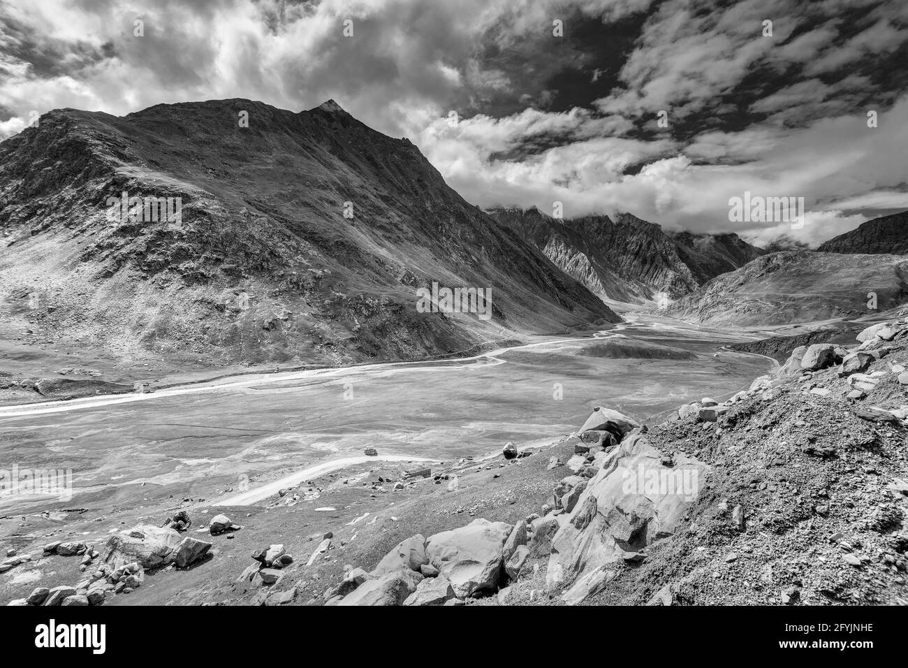 Rocky landscape of Kargil with blue cloudy sky in background , green valley , Ladakh, Jammu and Kashmir, India. Black and white image. Stock Photo