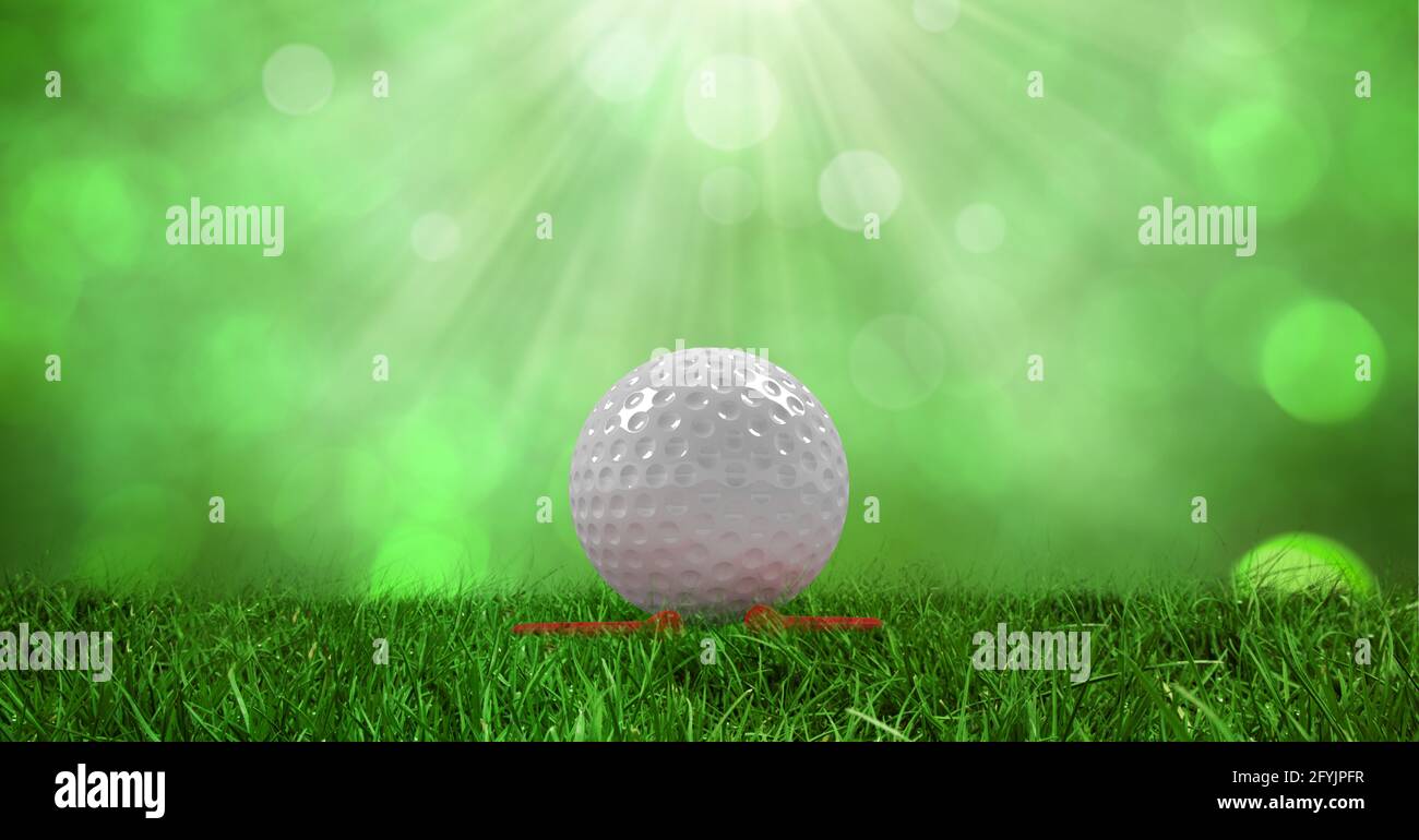 Composition of golf ball in grass on red tee with green glowing