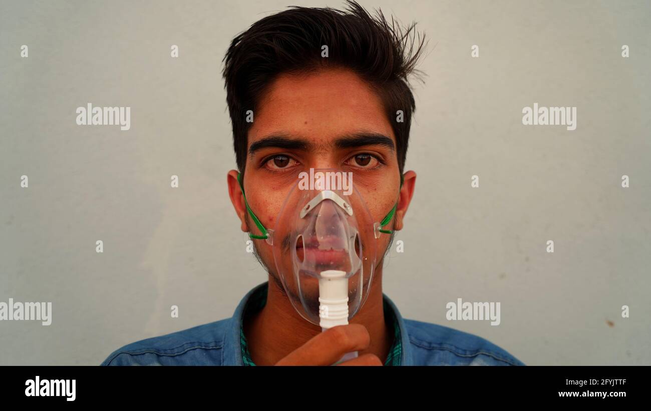 Young Man wearing oxygen mask at the home alone. A Coronavirus infected