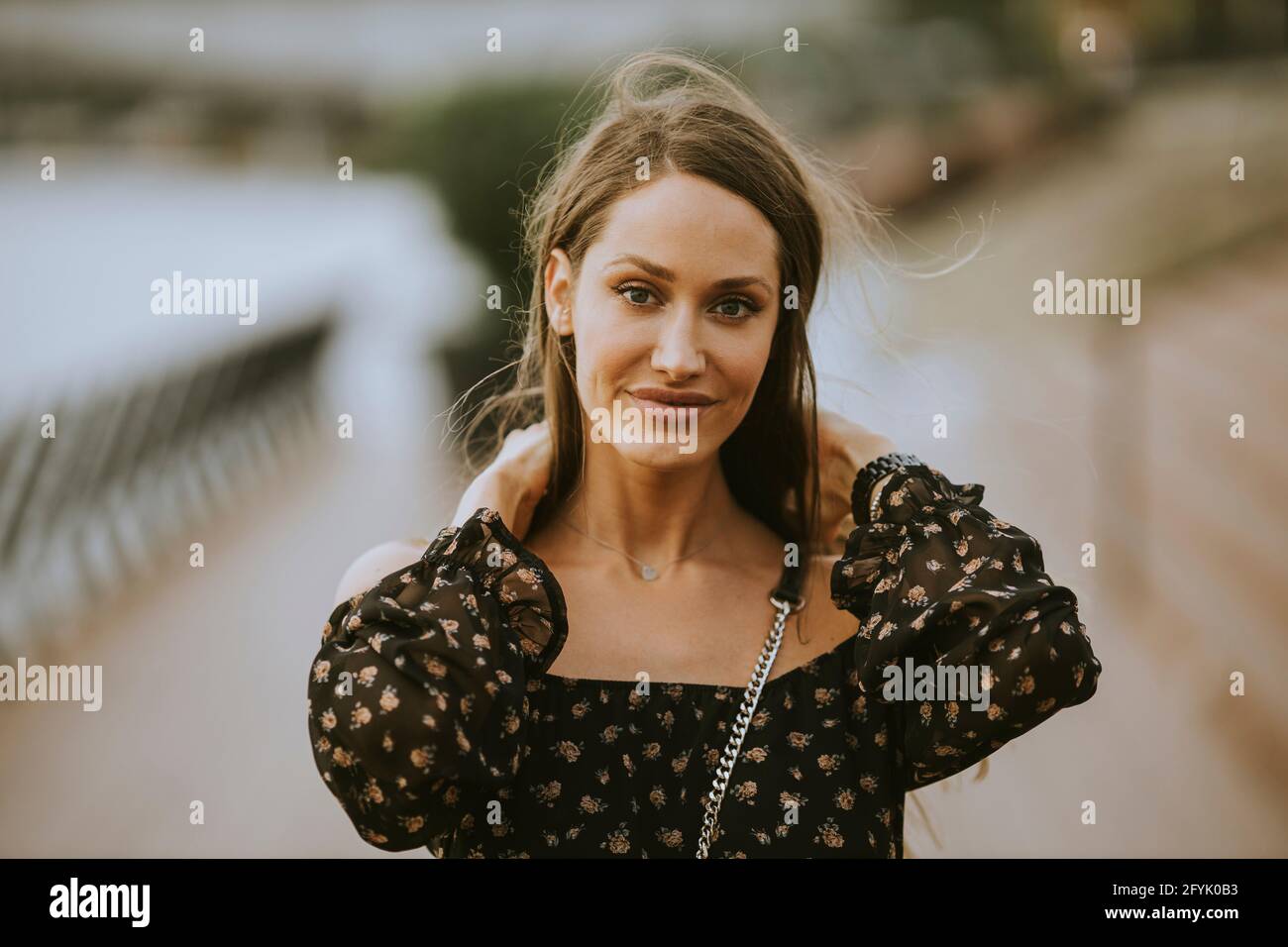 Pretty young long hair brunette woman walking on the riverside Stock ...
