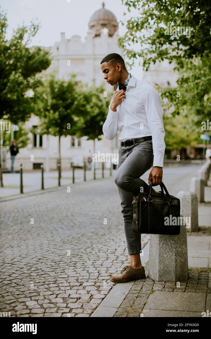 Handsome young African American businessman waitng a taxi on a street Stock Photo