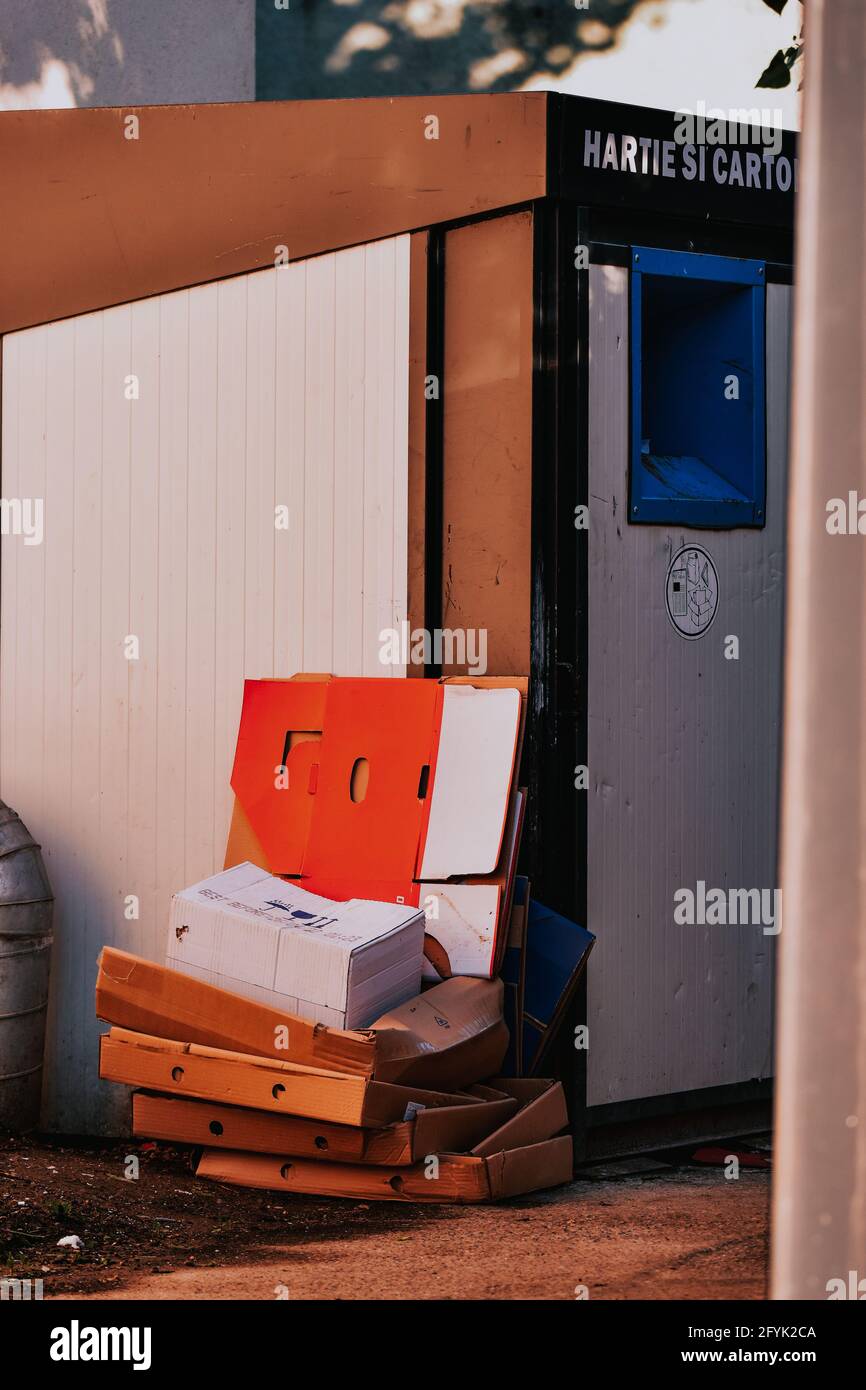 A pile of used and wornout cardboard boxes outside a paper and