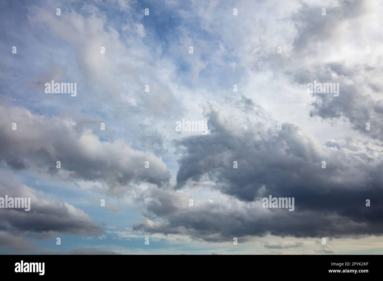 Overcast with images concept. Heavy dark clouds on colorful blue sky background, space. Cloudscape to horizon form figures of angry wild dragons ready Stock Photo