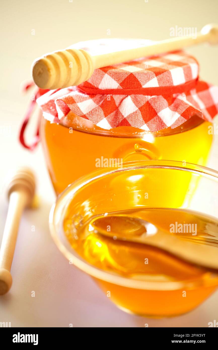 Natural honey in the jar along with honey spoon on the white background Stock Photo