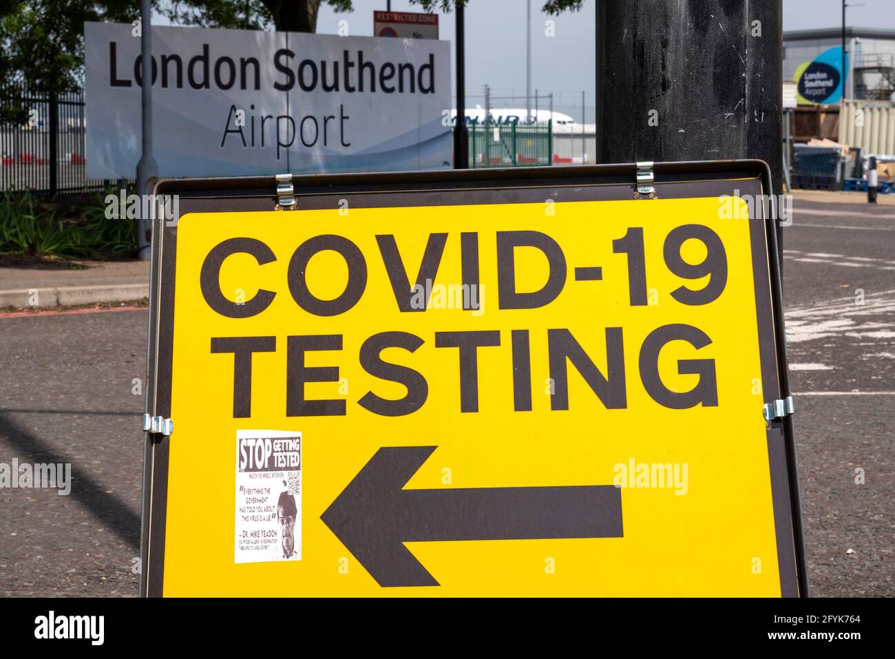 COVID 19 testing station sign at London Southend Airport, Essex, UK. Airport sign. COVID denier fake news sticker on sign Stock Photo