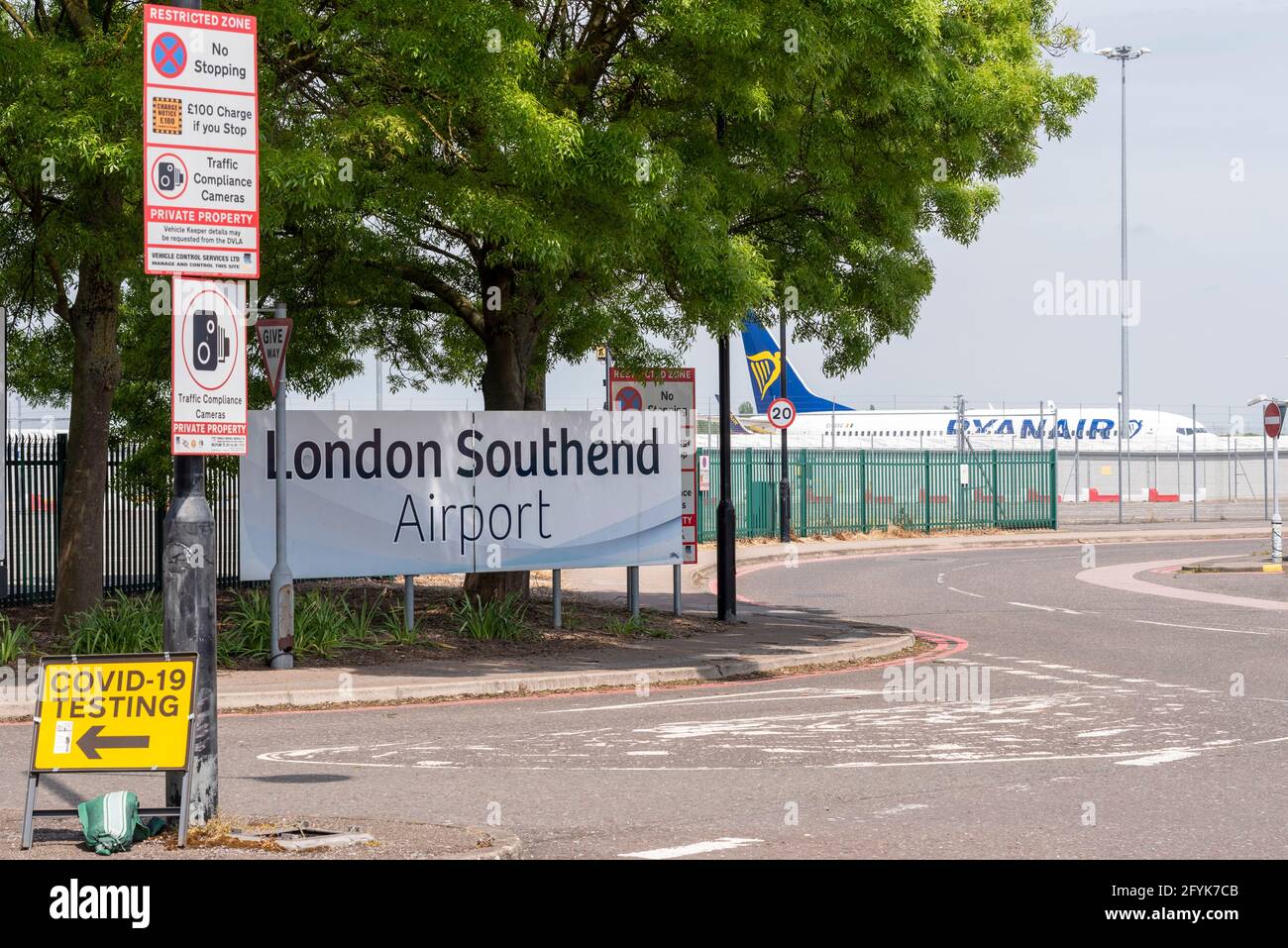 COVID 19 testing station sign at London Southend Airport, Essex, UK. With airport entrance sign and Ryanair Boeing 737 plane Stock Photo
