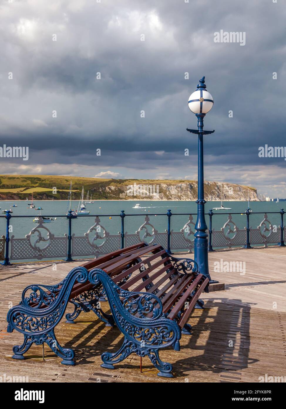 View from the Victorian Swanage pier across the bay with the coastal landmarks of Ballard Down and Old Harry Rocks in the distance. Stock Photo