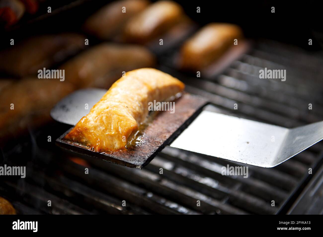 Salmon grilling on a BBQ with a cedar plank Stock Photo Alamy