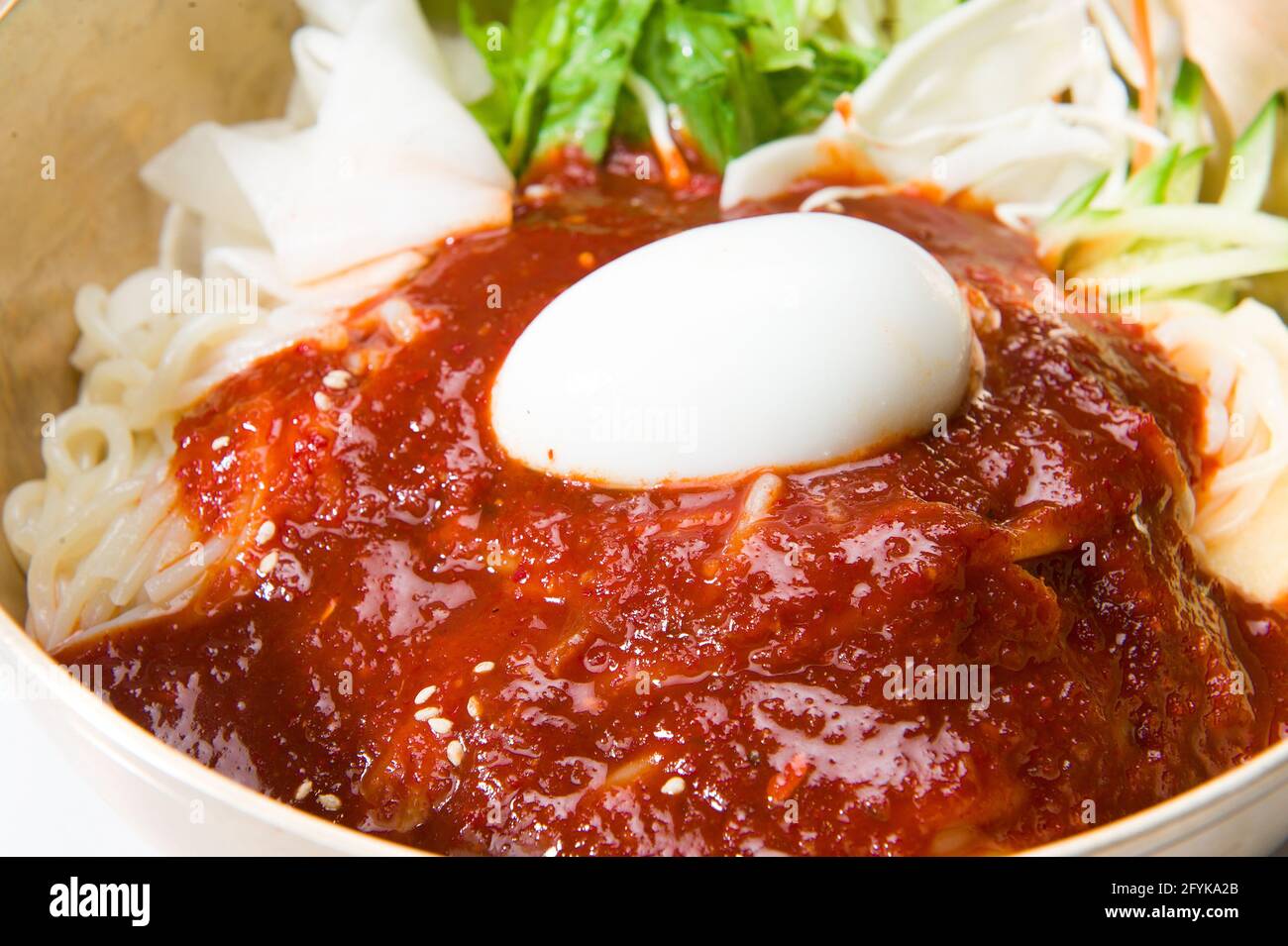 Asian noodles, salad, kimchi sauce, and a hard boiled egg at a Korean