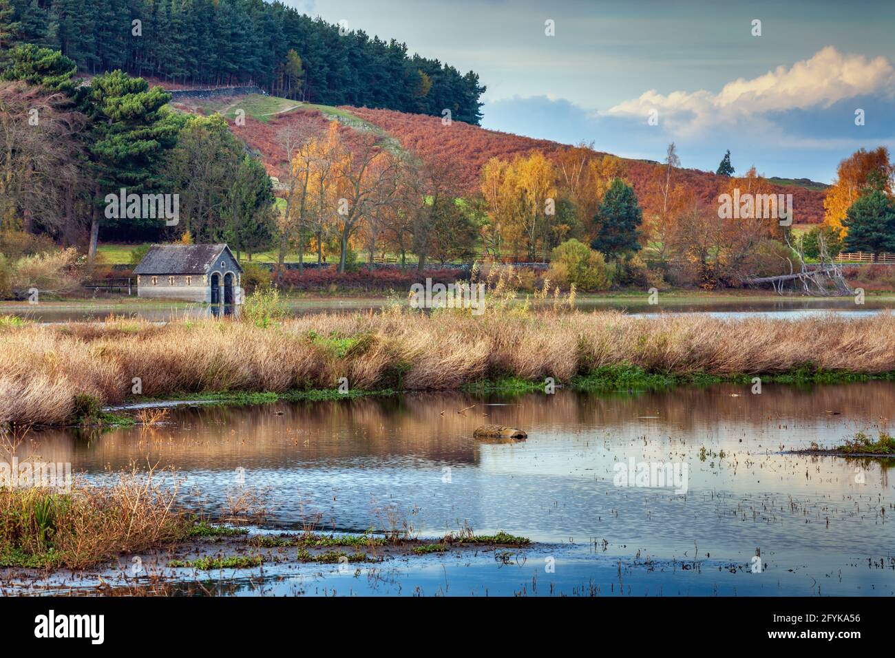 A view across Cropston Reservoir, with its picturesque boathouse, towards Bradgate Park in Leicestershire, capturing the wonderful  autumn colours. Stock Photo