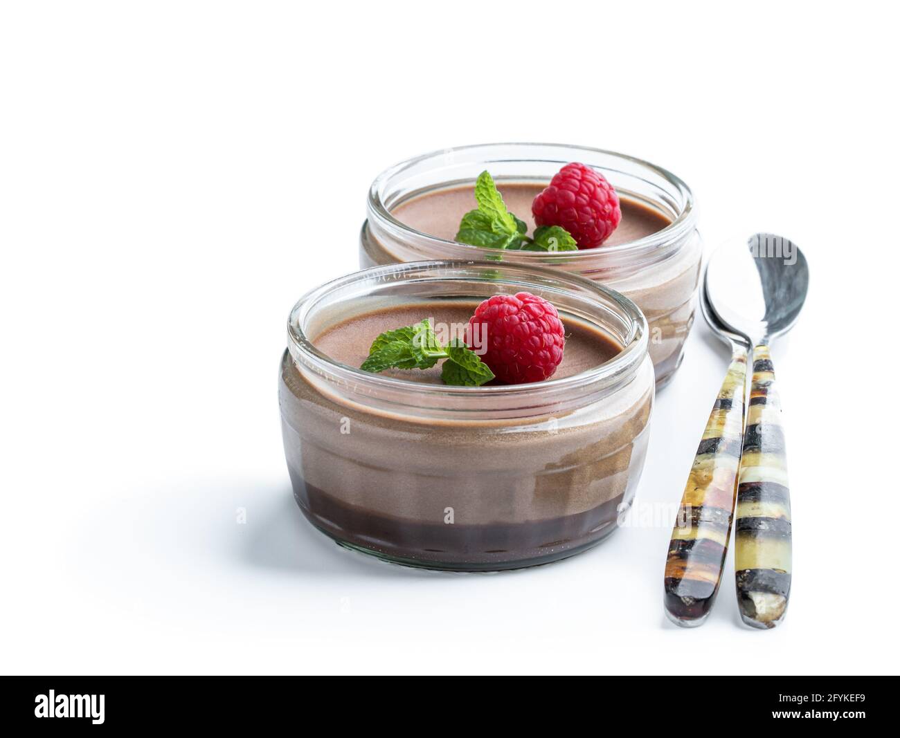 Mini caramel cheesecakes with raspberry in a glass pots isolated on