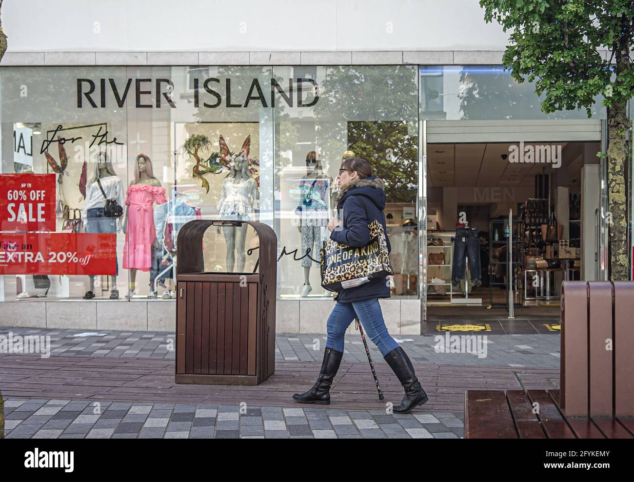 A shopper passes by River Island Clothes Store on Bow St Stock Photo