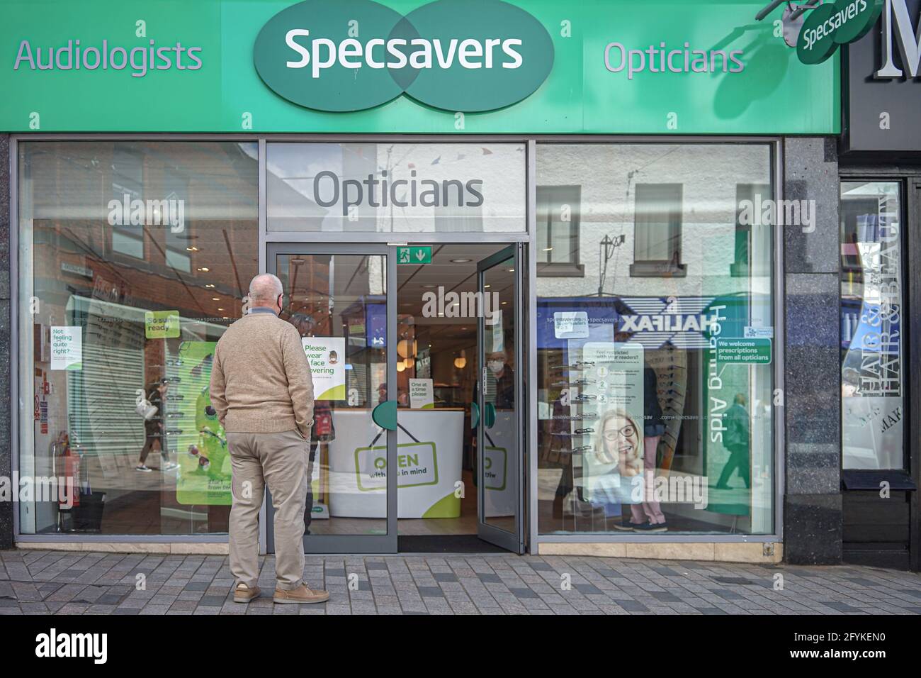A customer queues at Specsavers Opticians on Bow St. Stock Photo