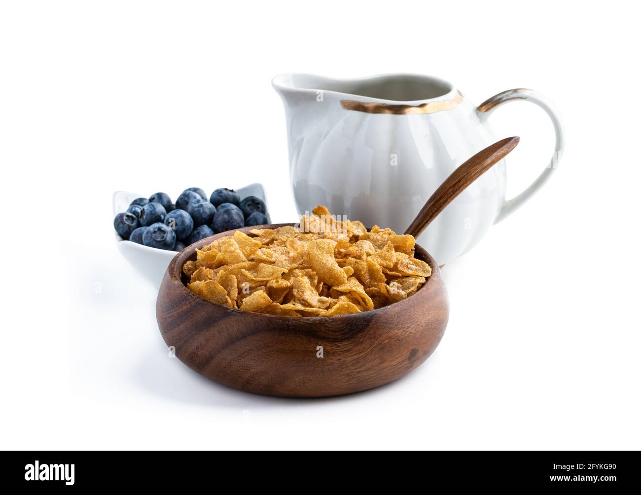 Corn flakes with jar of milk in wooden bowl isolated on white