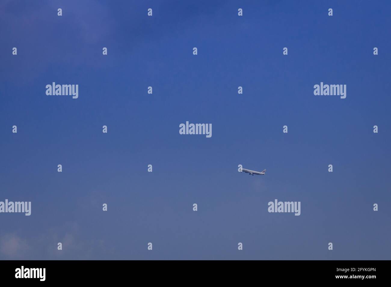 Propeller plane lit by the sun against a blue sky with white clouds and ...