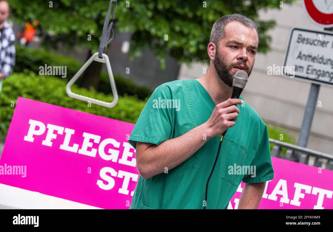 Munich, Bavaria, Germany. 28th May, 2021. ANDREAS KRAHL of the Bavarian Greens wearing his hospital scrubs Kahl works in an Intensive Care Unit in Murnau and detailed the poor treatment of the healthcare workers by the Bavarian government that promotes overwork, poorer care quality, and burnout syndrome. The Bavarian Greens (die Gruenen/Buendnis90) organized a protest action at the Bavarian Staatskanzlei (government building) in support of healthcare workers. During the Coronavirus crisis, the working conditions for this sector have come into greater focus and The Greens are pushing for bette Stock Photo