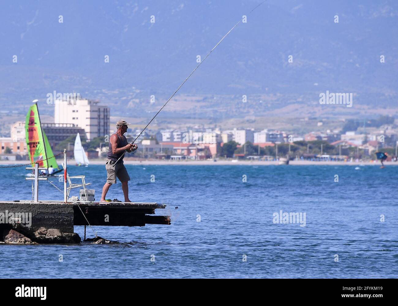 Cagliari, Italy. 28th May, 2021. A man fishes at the seaside in Cagliari, Sardinia, Italy, on May 28, 2021. All Italian regions have turned to 'yellow' since Monday, indicating a low risk of contagion, and the lowest level of anti-COVID-19 restrictions, according to the country's national health authorities. Credit: Alberto Lingria/Xinhua/Alamy Live News Stock Photo