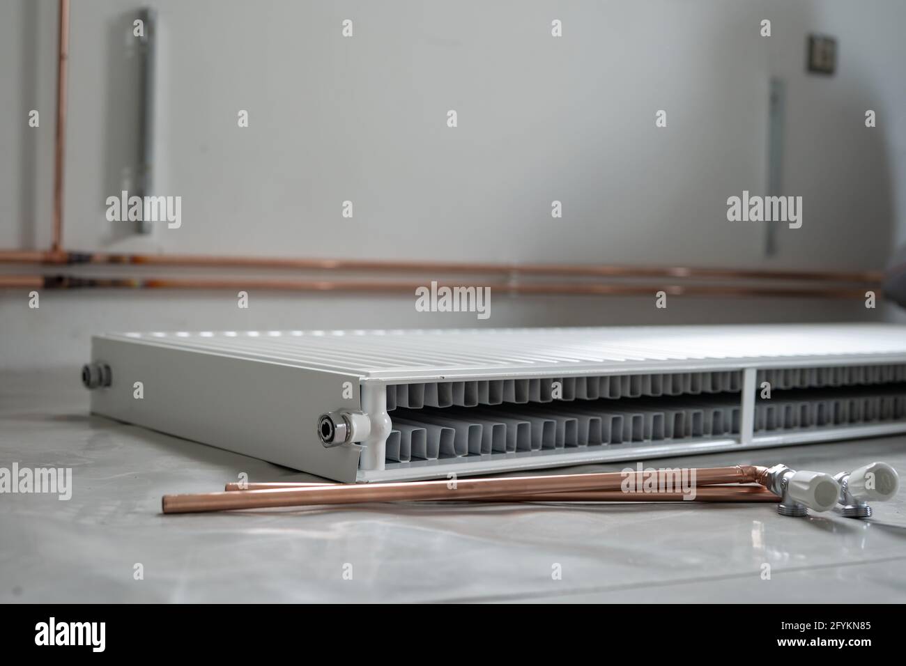 Central heating pipes and radiator on the floor at construction site in apartment house or