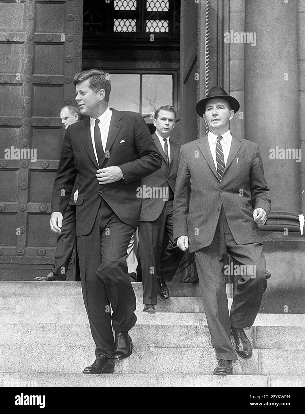 1 November 1961 President John F. Kennedy departs the Cathedral of St. Matthew the Apostle (St. Matthew’s Cathedral) after attending a Mass in observance of All Saints Day. (L-R) President Kennedy, Secret Service Agent Bill Payne, and Special Assistant to the President Dave Powers. Washington, D.C. Stock Photo