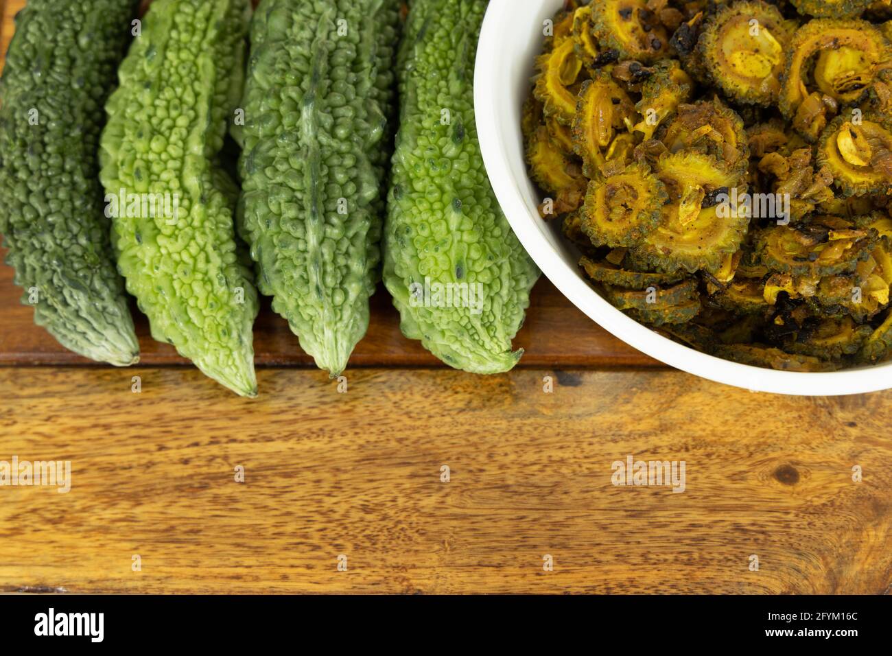Cooked bitter gourd and raw bitter gourd kept alongside each other