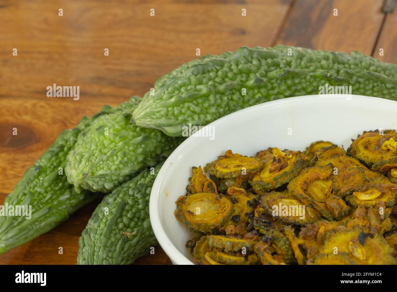 Cooked bitter gourd and raw bitter gourd kept alongside each other