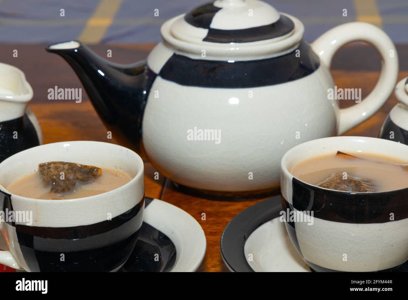 Milk Tea served in a ceramic tea set with design and tea bags inside