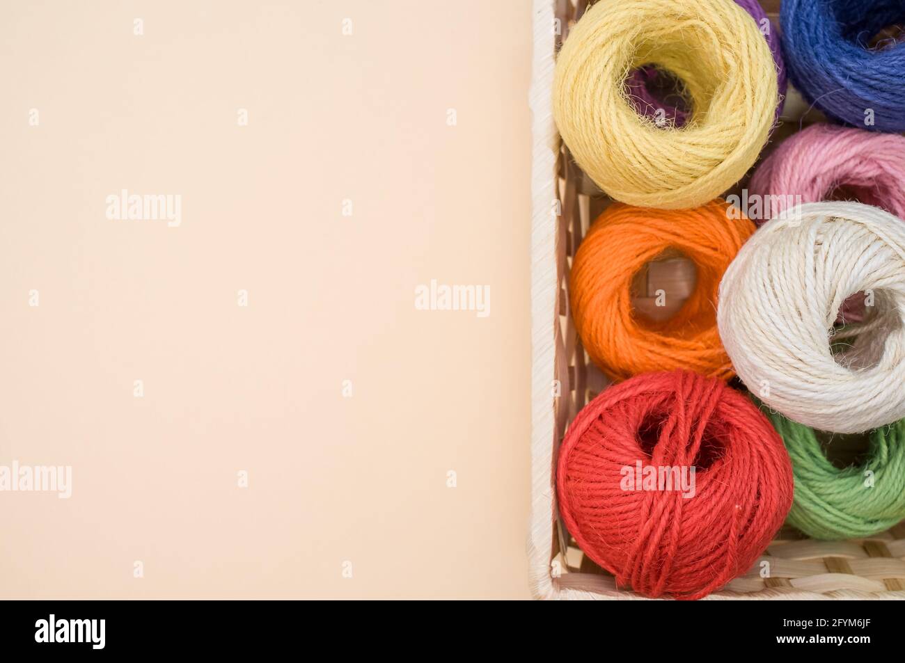 Thread rolls in a box isolated on a beige background Stock Photo - Alamy