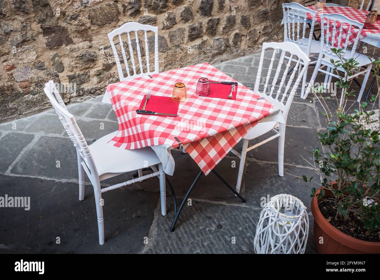 Set Table on a Street in Montalcino, Tuscany, Italy, with Checkered Red and White Tablecloth, in the Old Town Stock Photo