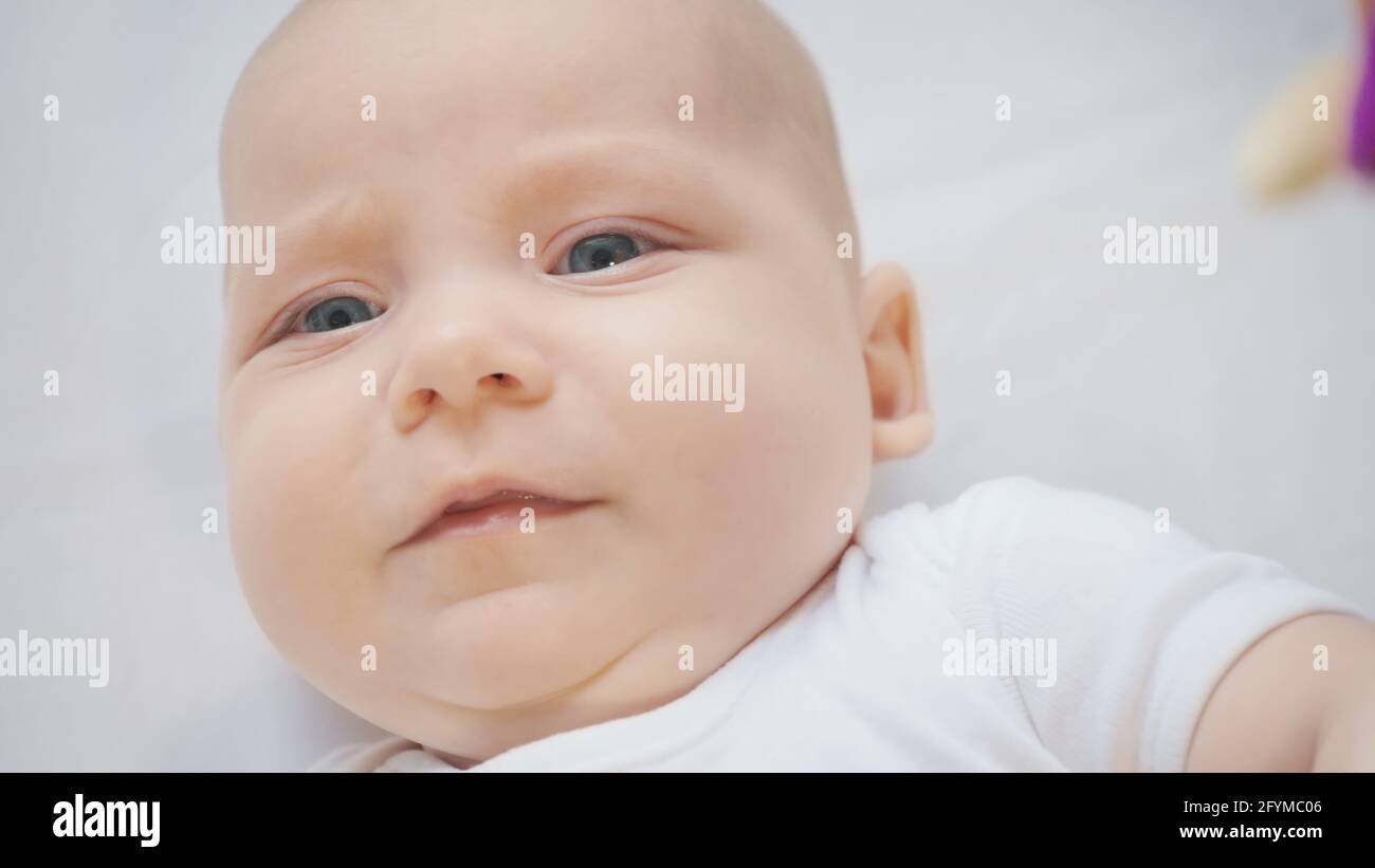 Photo of lying unhappy baby four month girl Stock Photo