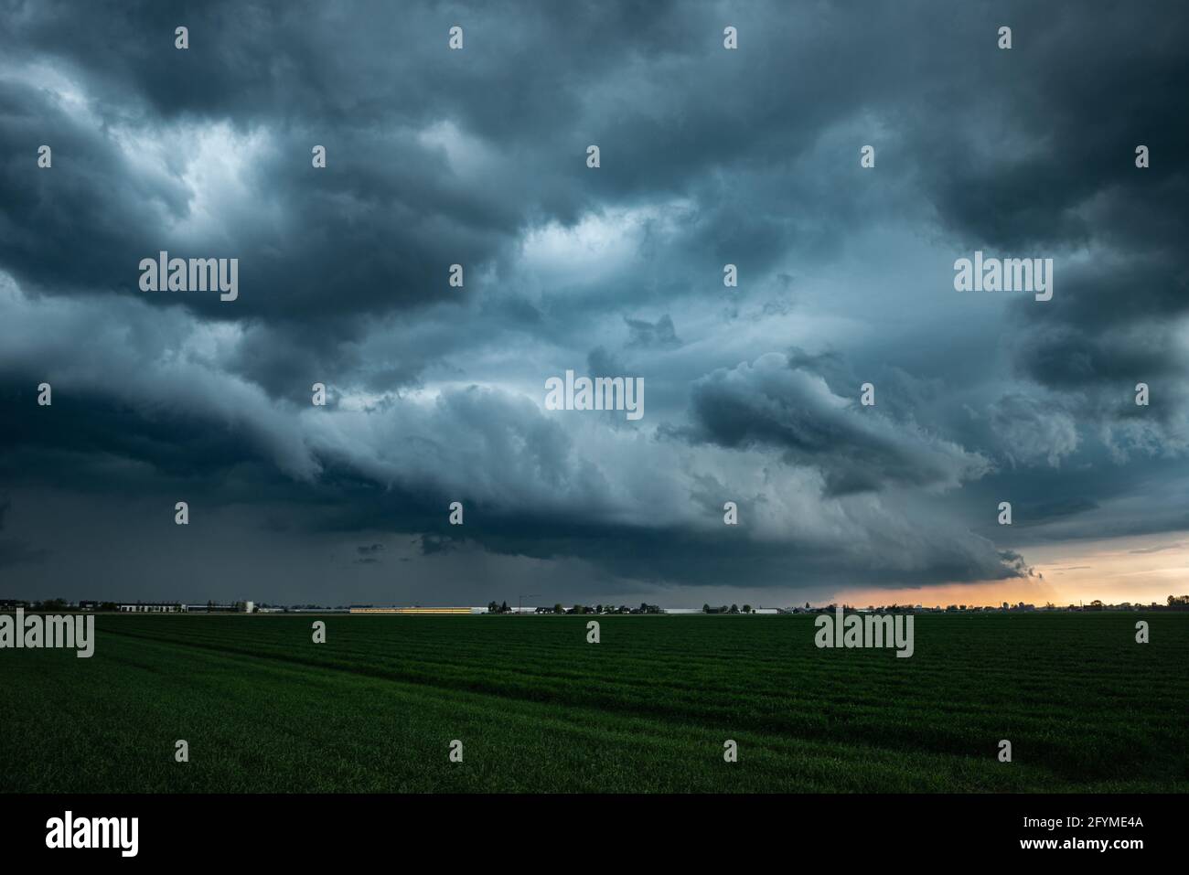 Approaching shelf cloud of a thunderstorm in the evening light Stock Photo