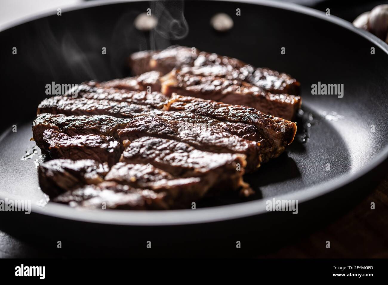 Fat unhealthy grilled beef strak in teflon pan Stock Photo Alamy