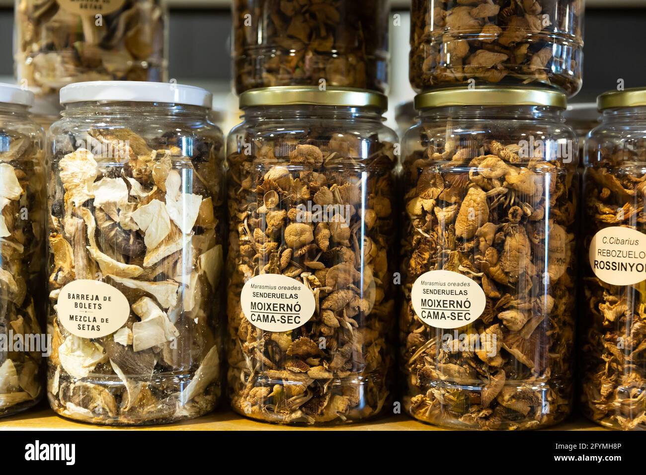 Assortment of dried mushrooms in jars at grocery store showcase Stock Photo