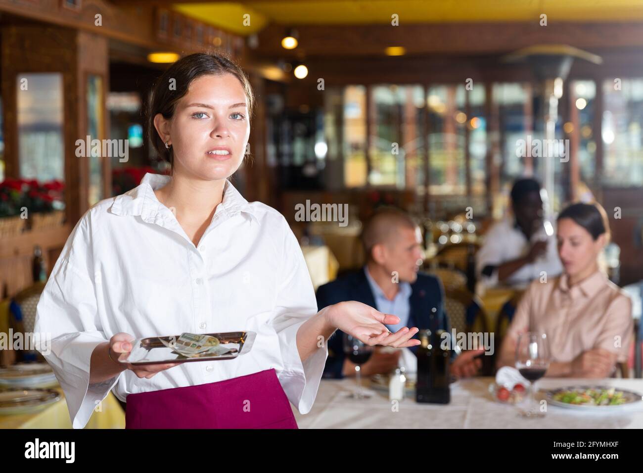 Beatiful woman waiter demonstrating her upset with small tip in restaurant Stock Photo