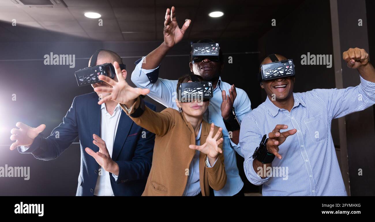 Cheerful nice friends playing  video games using virtual reality glasses Stock Photo
