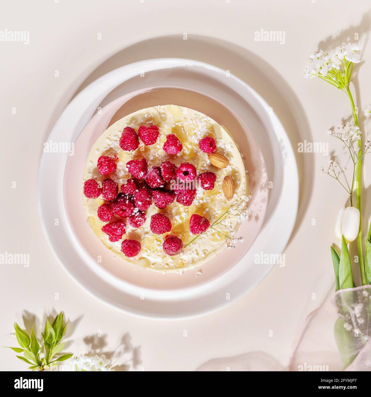 Home made, raspberry, almond cake on a white plate on a pink background. Sweet pastries with almond flour are gluten-free, low in carb. Keto diet Stock Photo