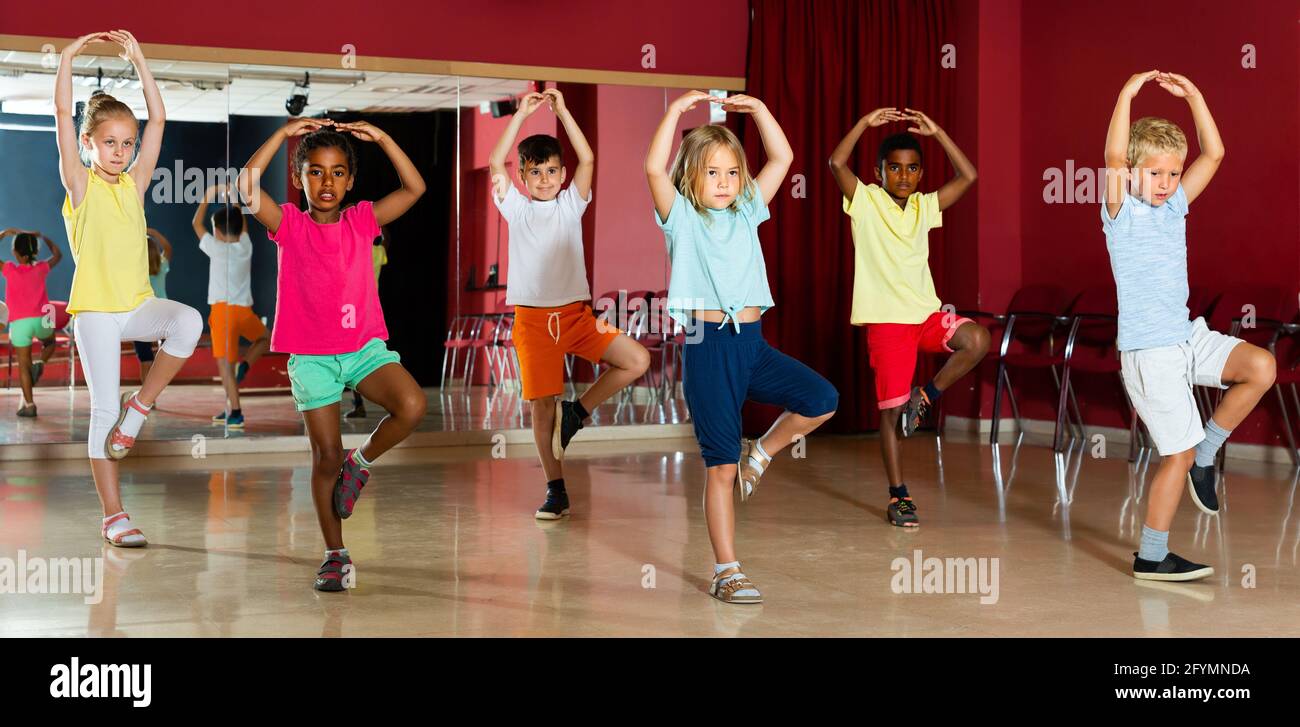 Cheerful little boys and beautiful girls having dancing class and hands ...
