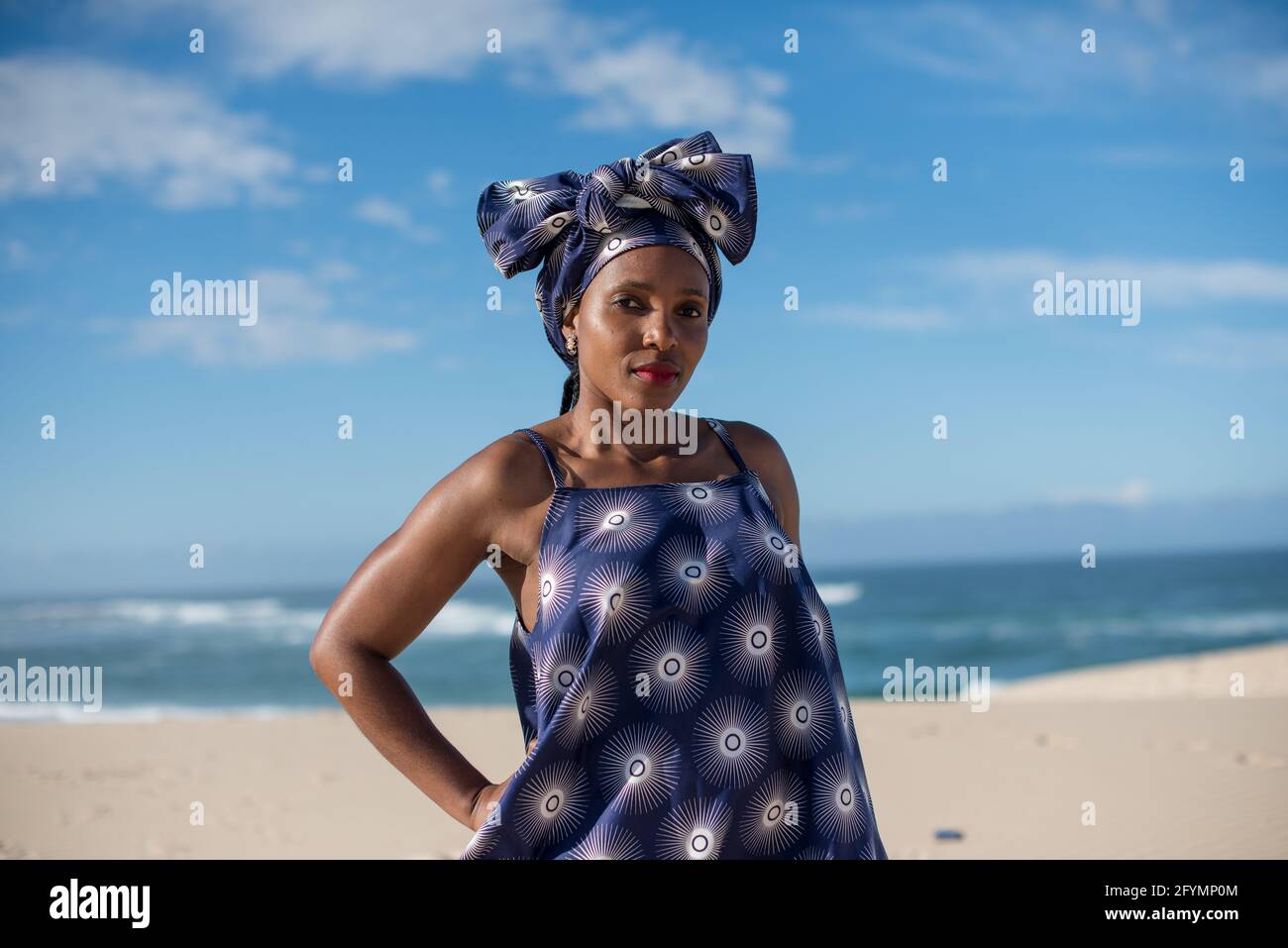 Portrait of woman standing on sand dunes at beach Stock Photo - Alamy