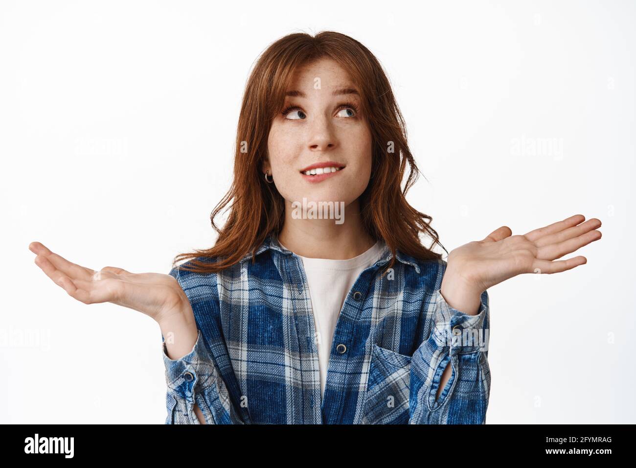 I dont know. Confused redhead girl shrugging and looking up with