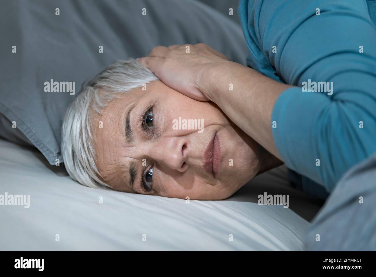 Noise keeping woman awake Stock Photo