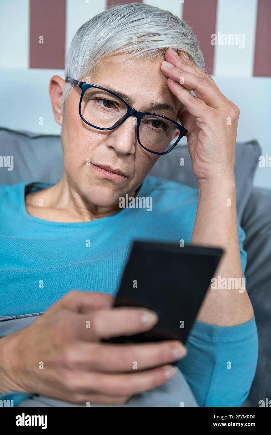 Woman using smartphone in bed Stock Photo